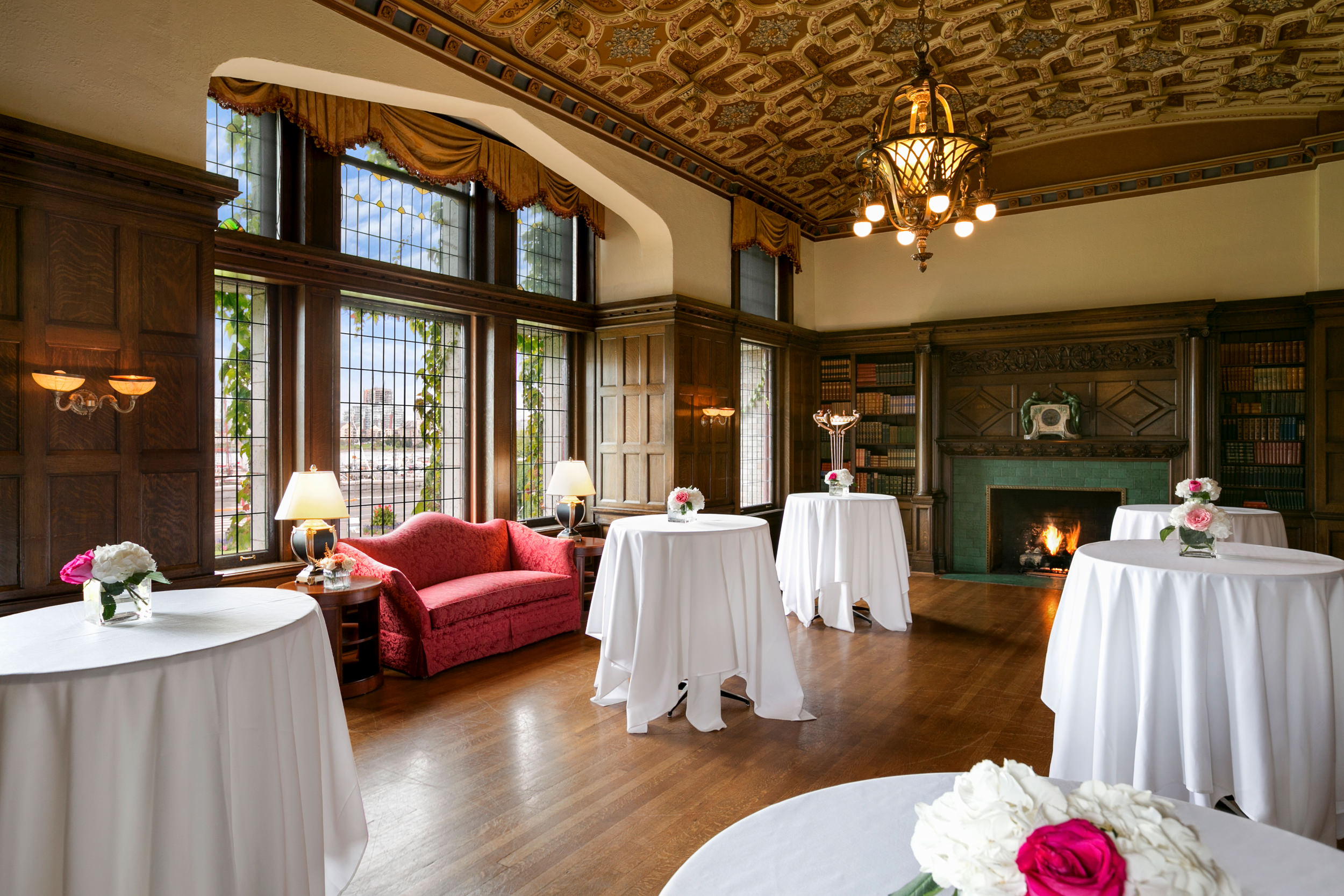 room with a fireplace and small round tables