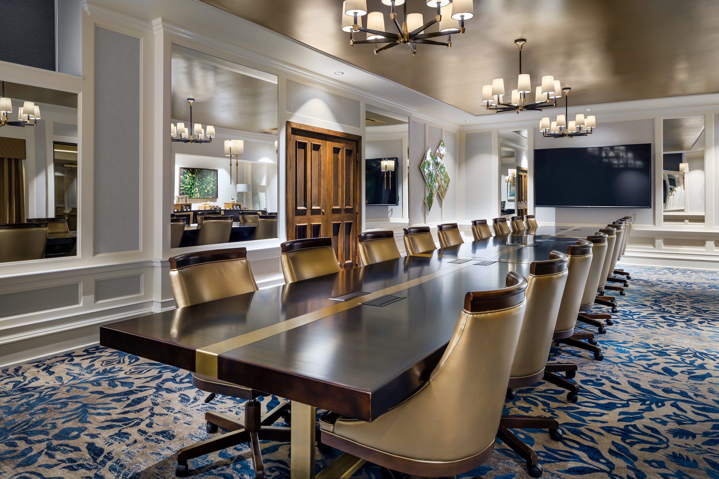 room with a long conference table and a television mounted to the wall