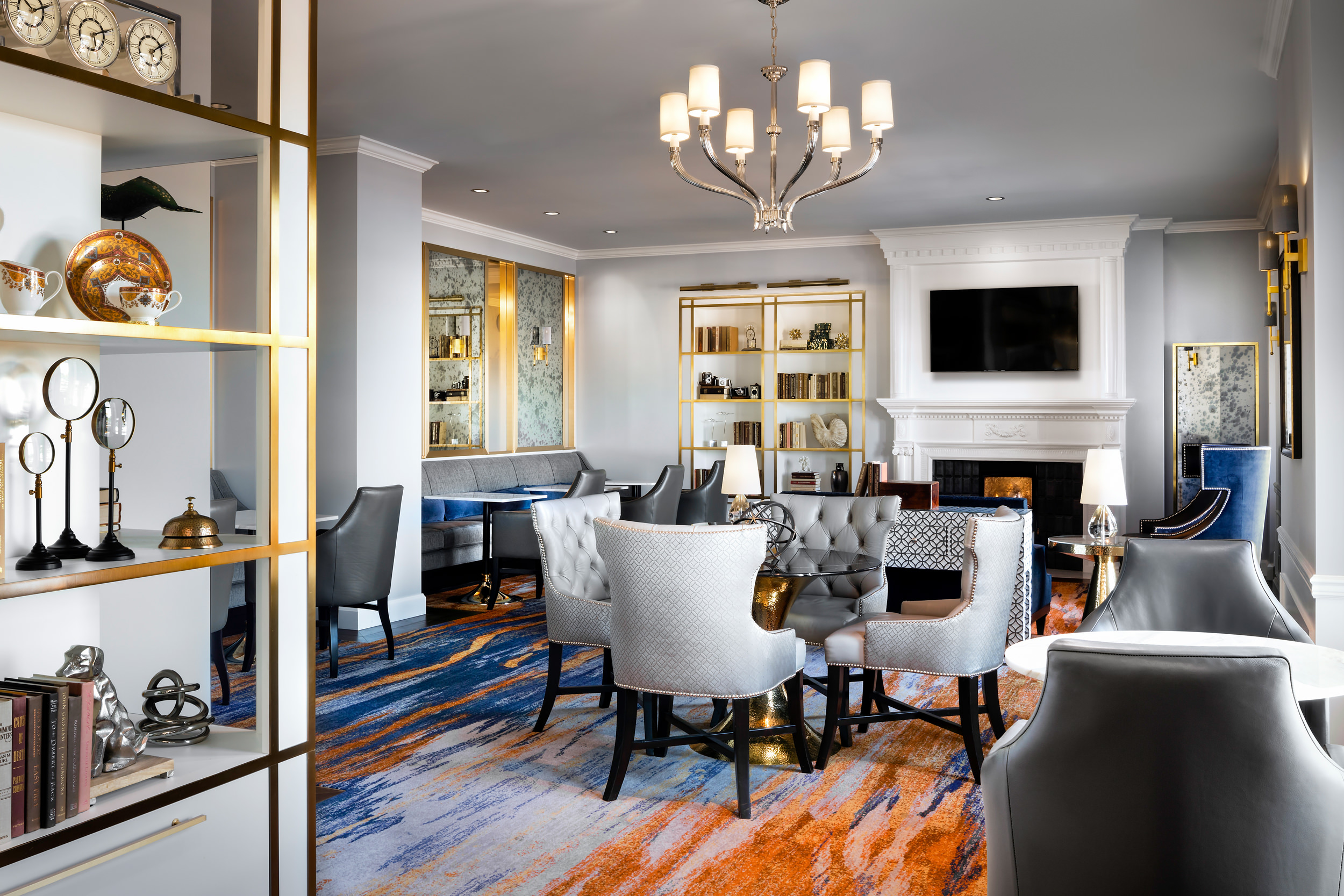 white room with a television, fireplace, and several seating areas