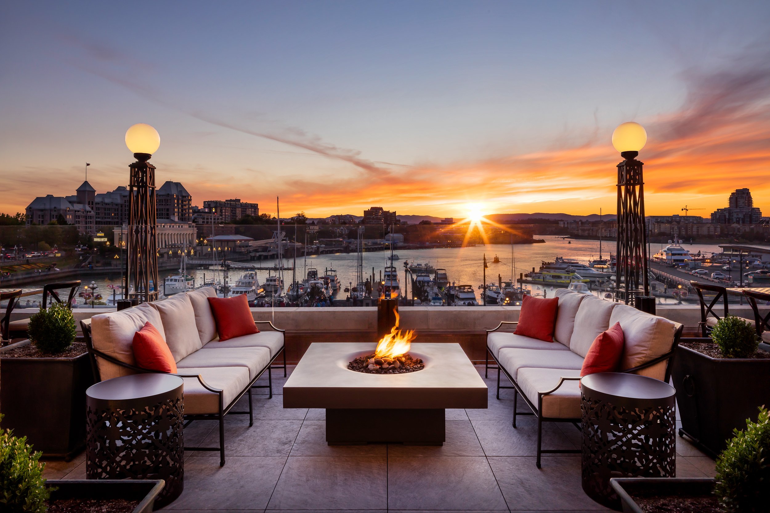 patio with a fireplace table overlooking the sunset on the harbour
