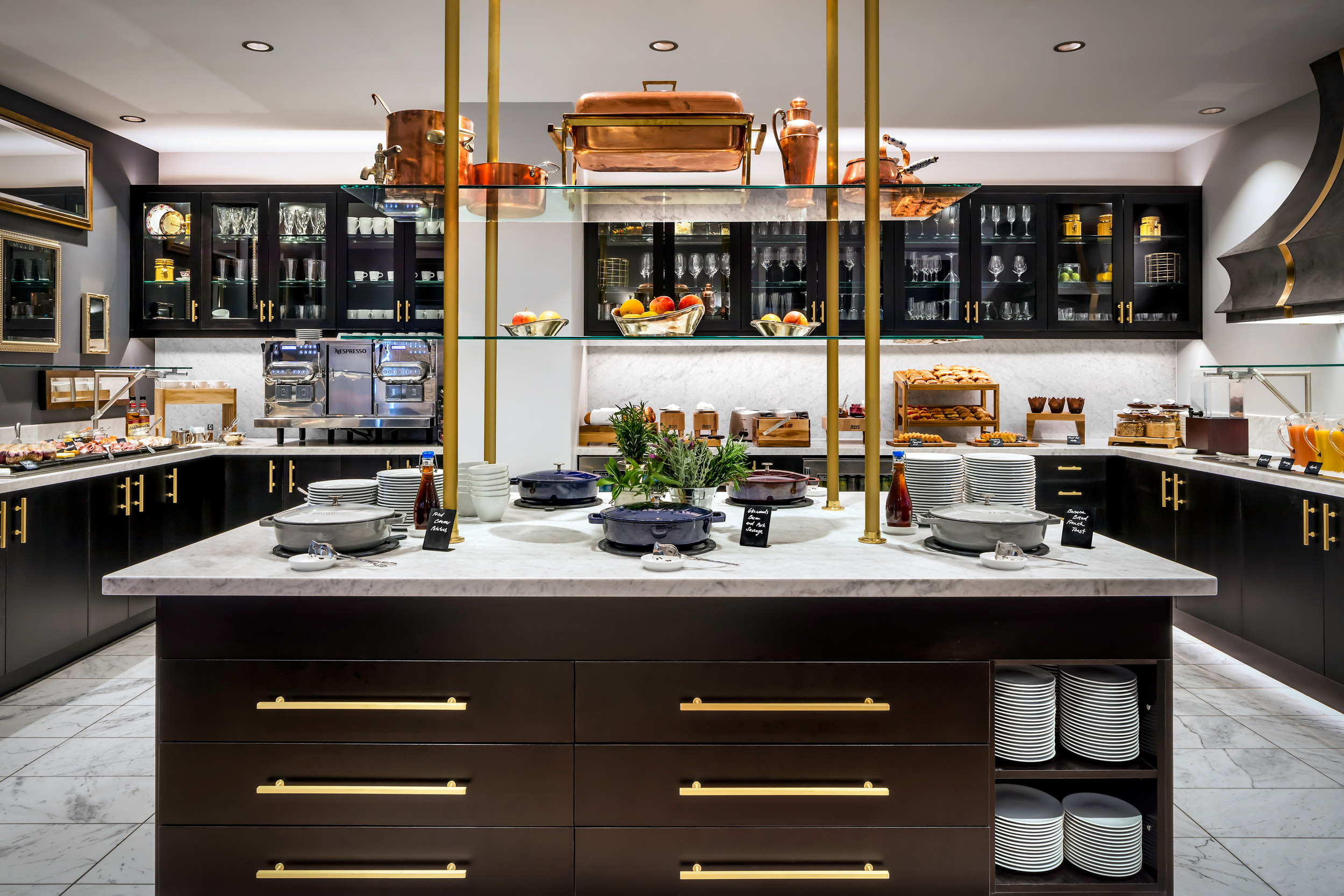 bright kitchen with brass accents and dark cabinets