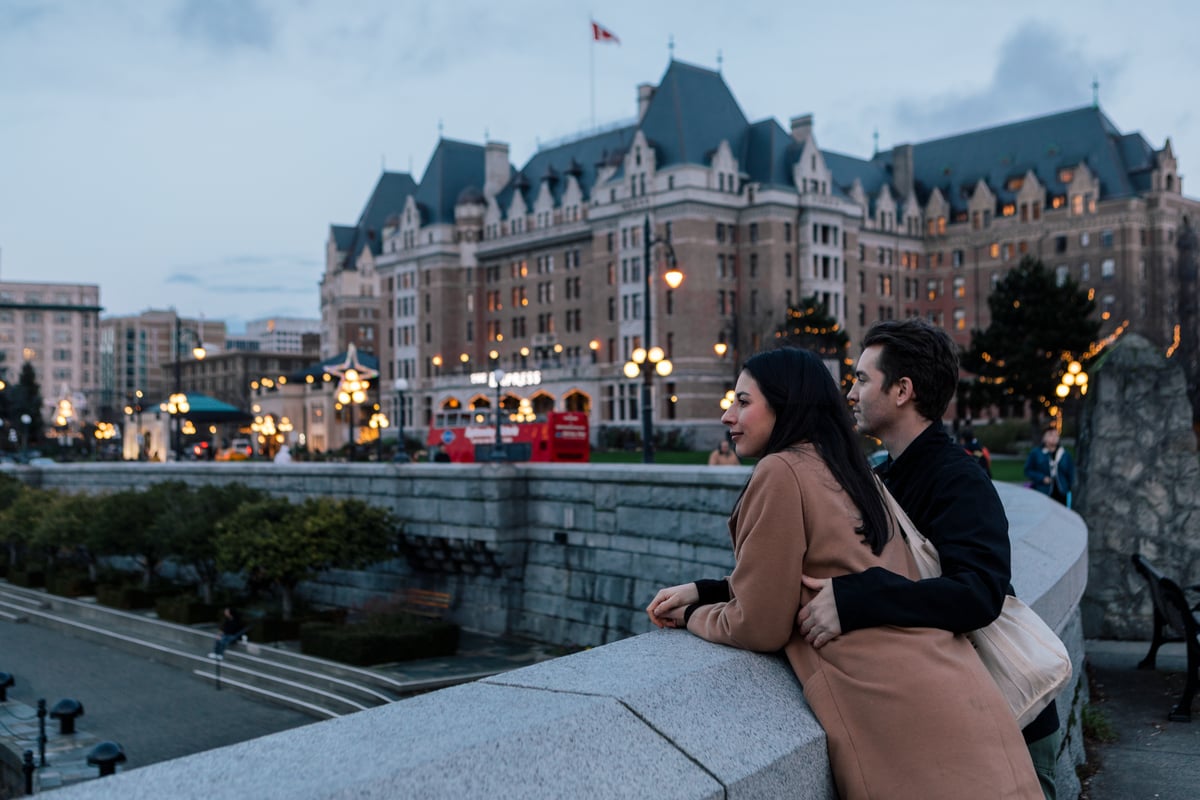Couple looking toward the Fairmont Empress in Victoria BC at dusk